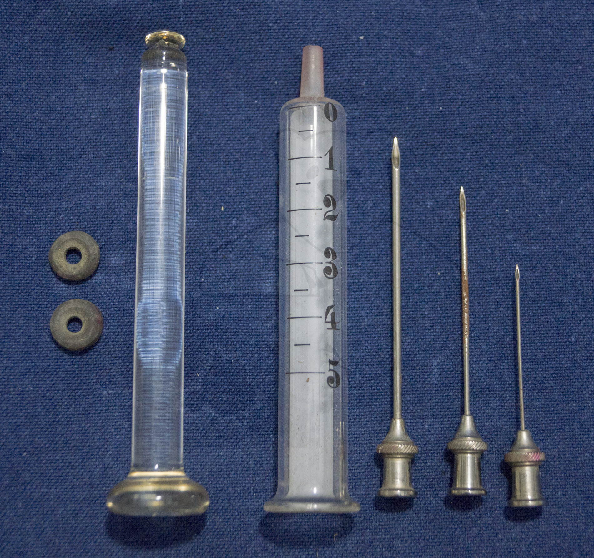 Handgemachte Glasspritze und Kanülen, um 1900, Spritze, Stempel, Kanülen, Dichtungen und Reinigungsdrähten